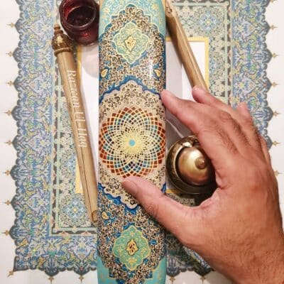 A hand carrying out Arabic calligraphy